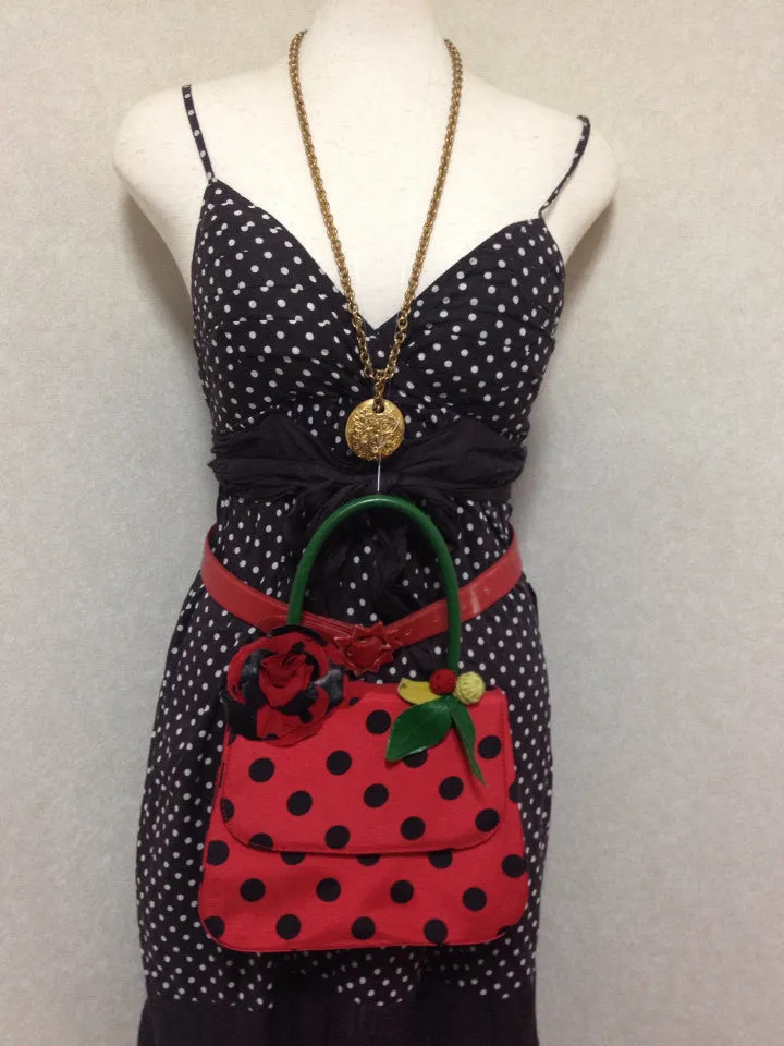 MINT. Vintage Moschino red and black canvas polkadot kelly handbag with a matching rose flower and leaf and crochet fruits motifs. 0506307