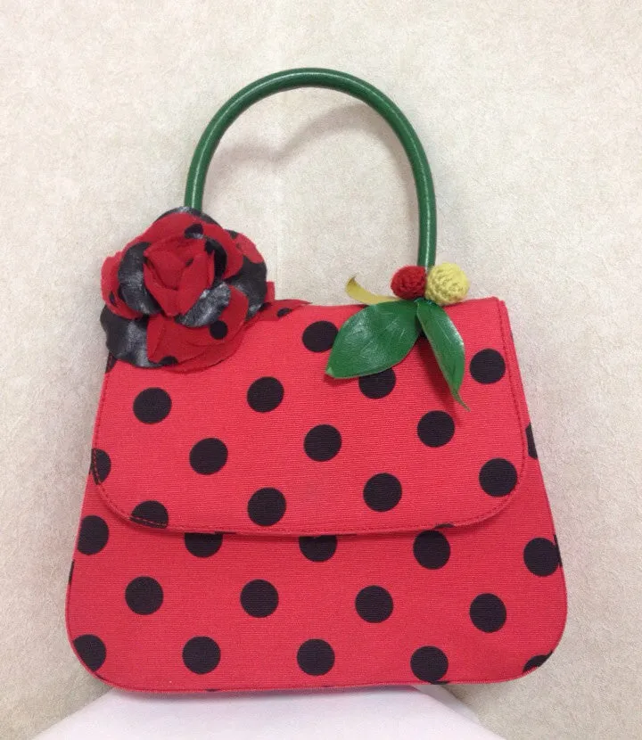 MINT. Vintage Moschino red and black canvas polkadot kelly handbag with a matching rose flower and leaf and crochet fruits motifs. 0506307